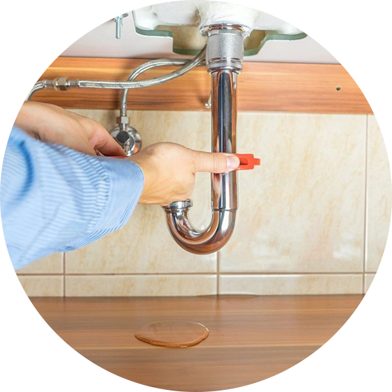 A person is pointing to the faucet of a kitchen sink.